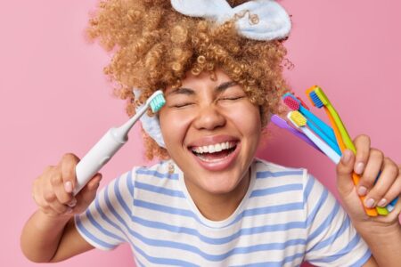 Questo spazzolino elettrico è in forte sconto su Amazon: gengive più sane col 57% di risparmio donna felice con spazzolino elettrico